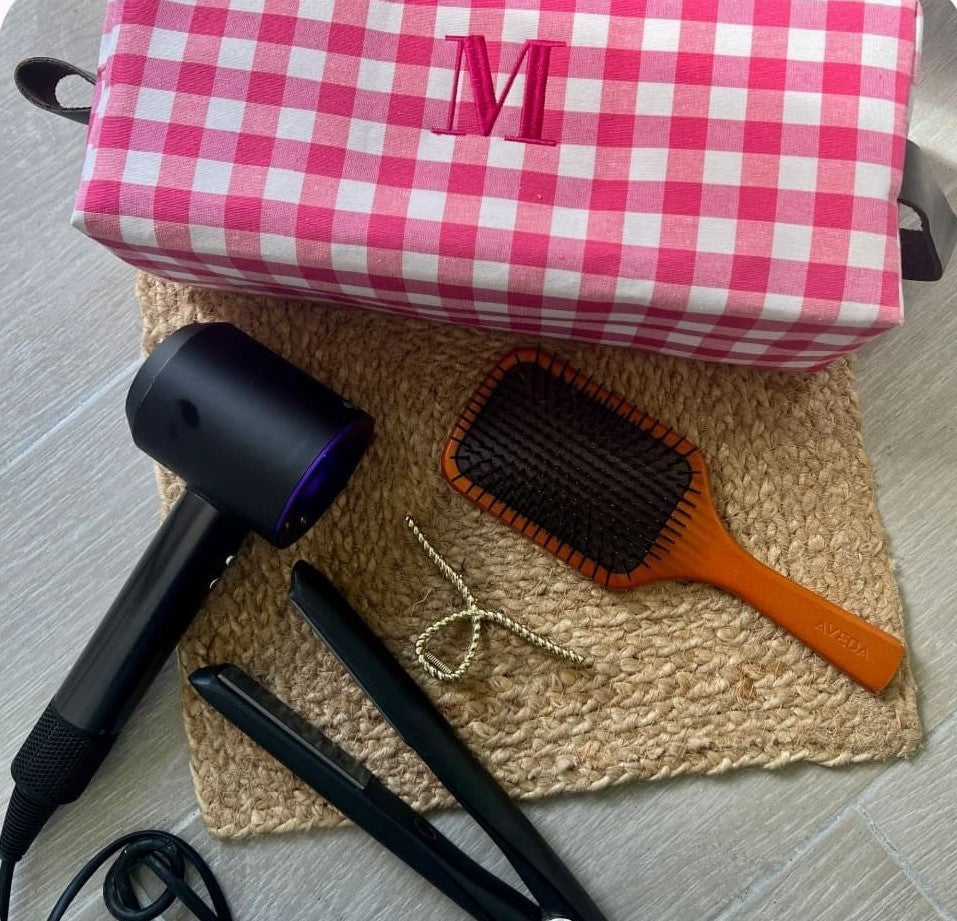 Neceser maxi en color rosa con cuadros vichy apoyado sobre neceseres azul y verde