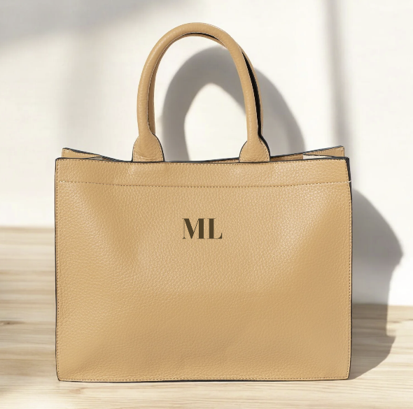 Vista frontal del Bolso Gassman en piel color camel con iniciales bordadas