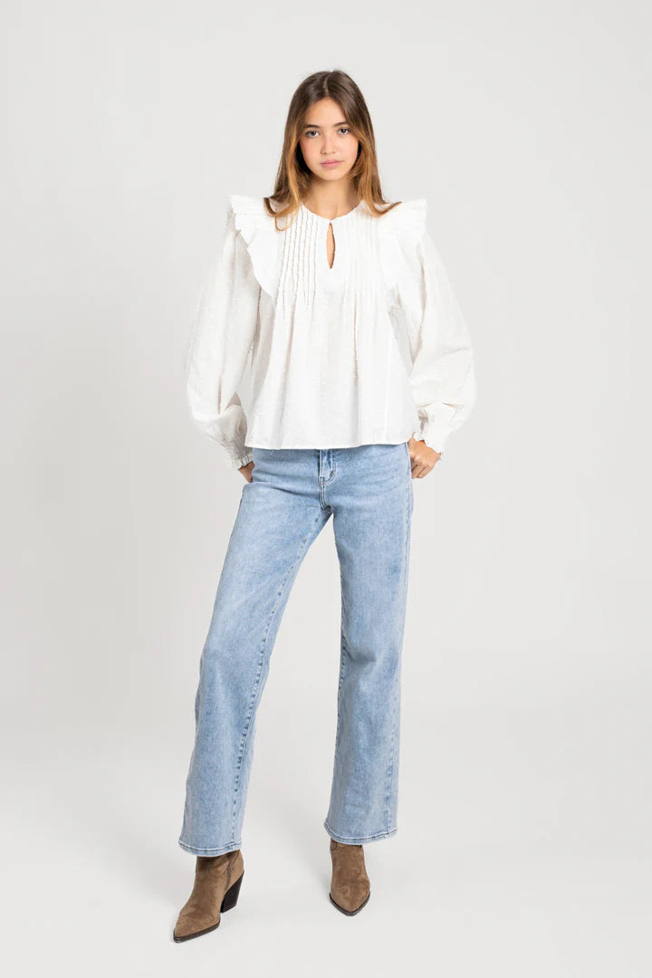 Mujer con blusa blanca de algodón con volantes y manga larga