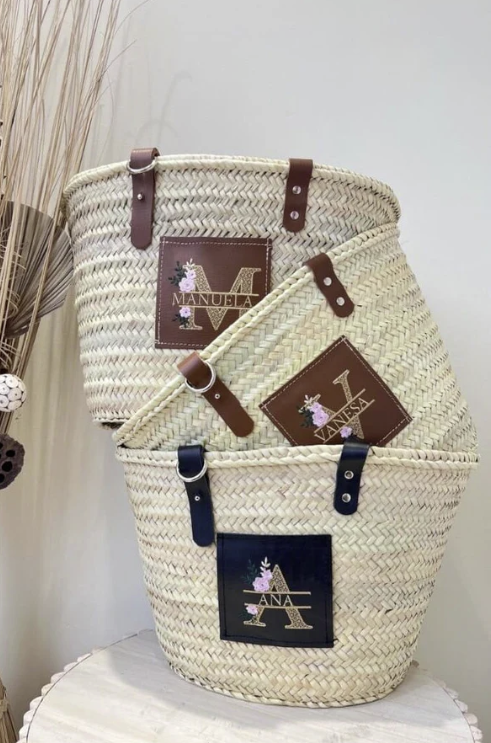 Capazo de palma con nombre bordado en cuero marrón, ideal para looks de primavera-verano

