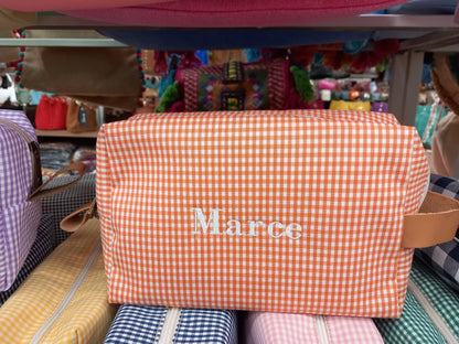 Neceser color naranja con cuadros blancos y el nombre "Marce" bordado, práctico y bonito