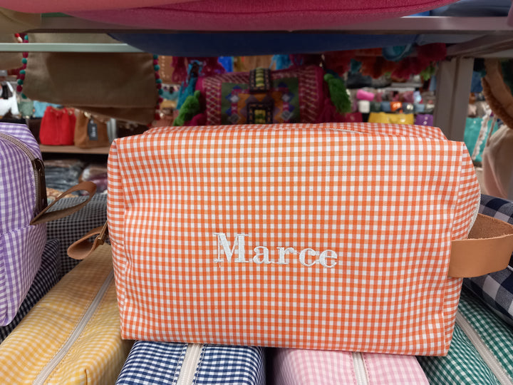 Neceser color naranja con cuadros blancos y el nombre "Marce" bordado, práctico y bonito
