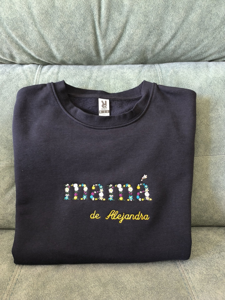 Detalle de varias sudaderas personalizadas con iniciales y nombres bordados en hilo colorido