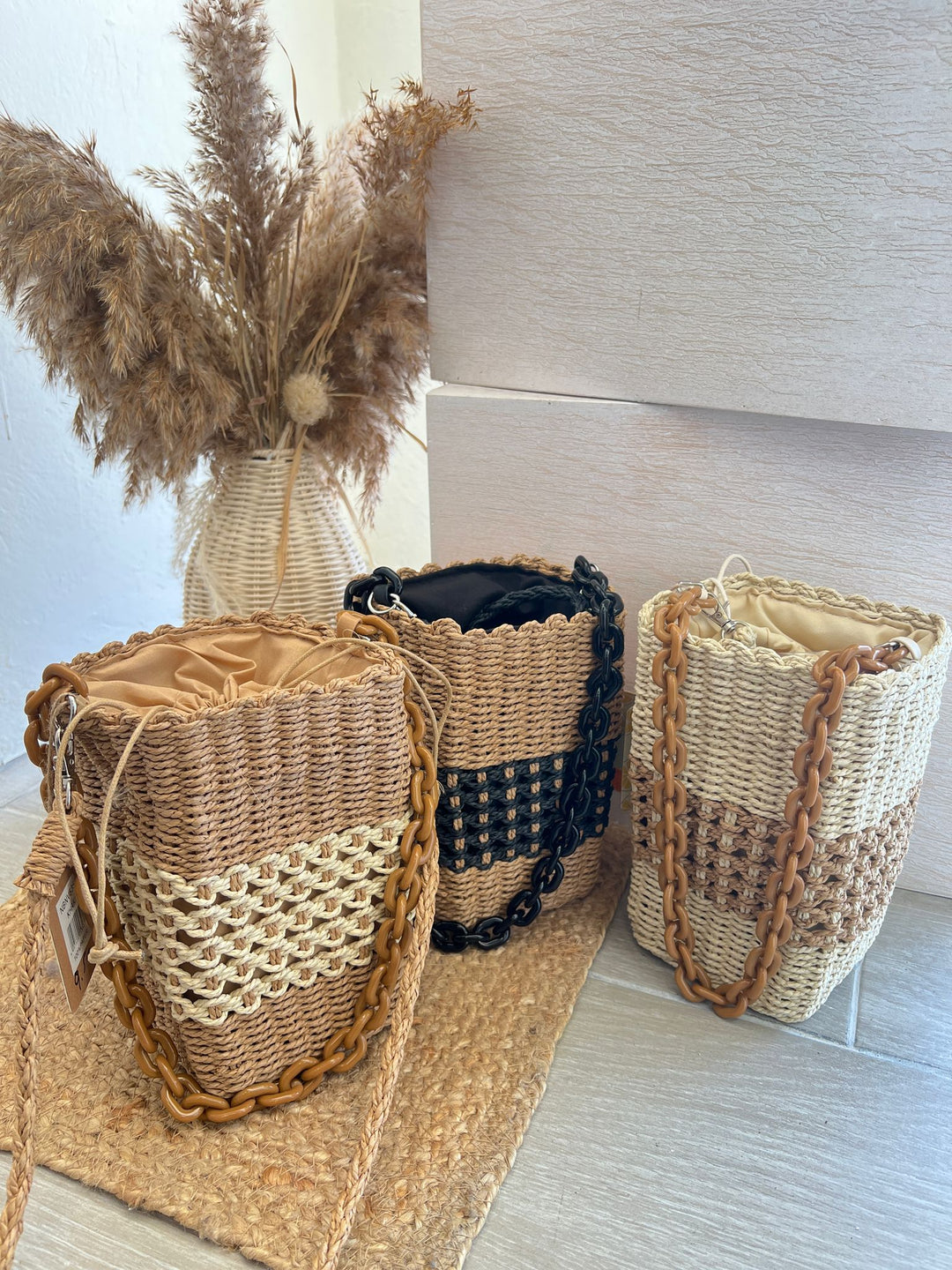 Capazo Ubud de estilo veraniego con cadena decorativa y cuerpo trenzado artesanal.

