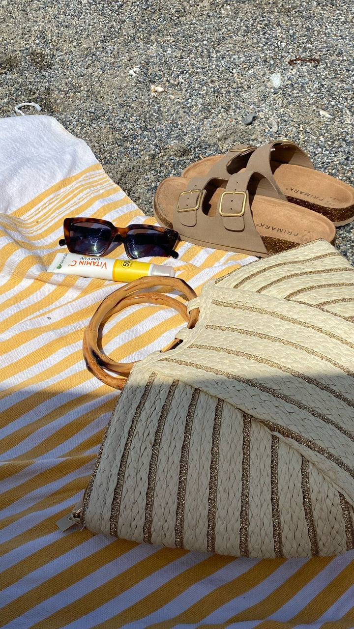 Look veraniego con capazo Kuta de rafia y detalles dorados, el accesorio imprescindible para esta temporada.

