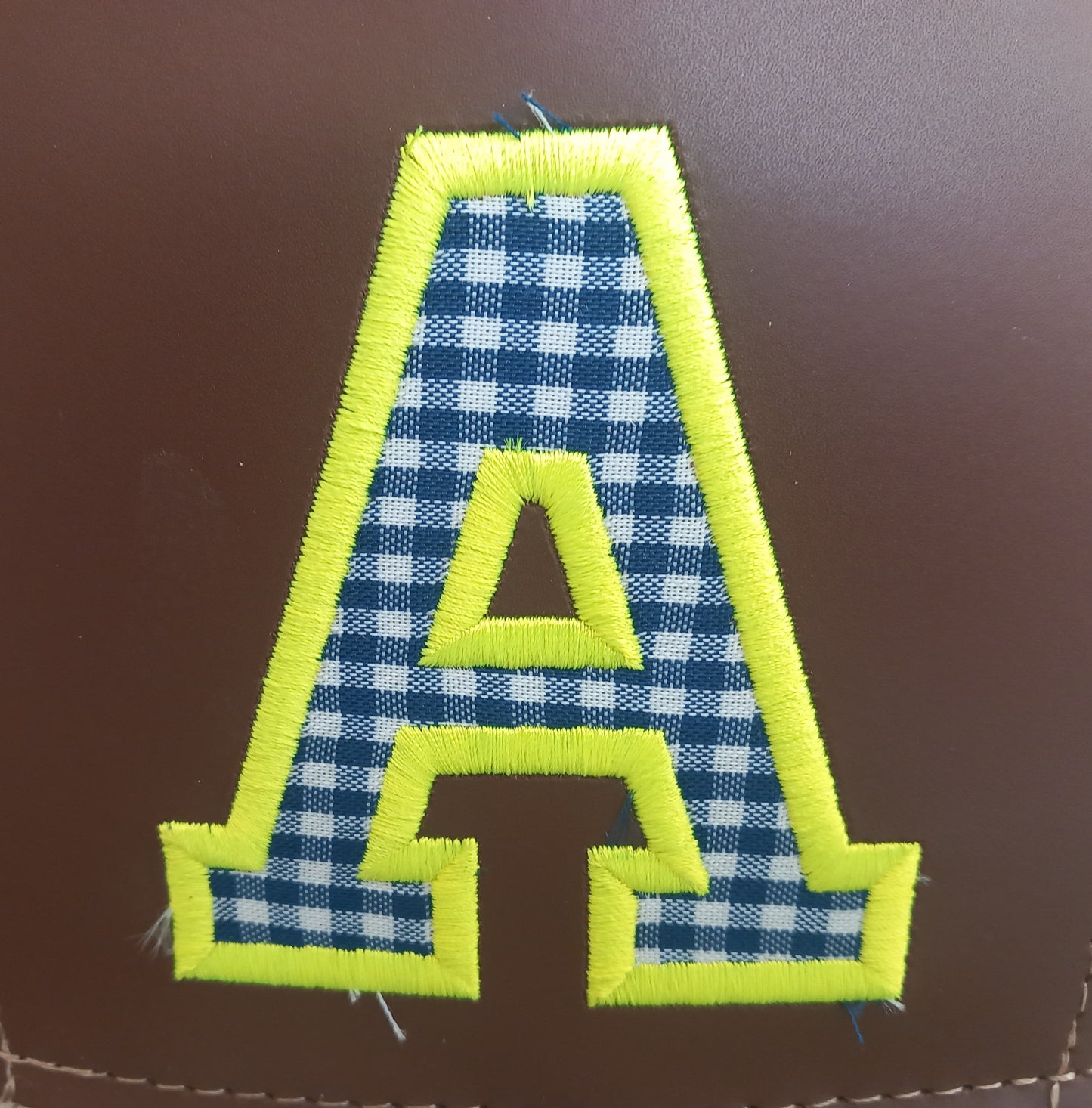 Bolso de palma personalizado con letra decorativa.


