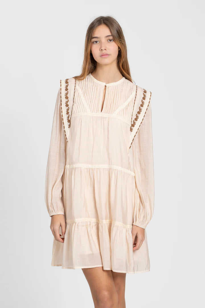 Detalle de bordados en vestido beige estilo romántico