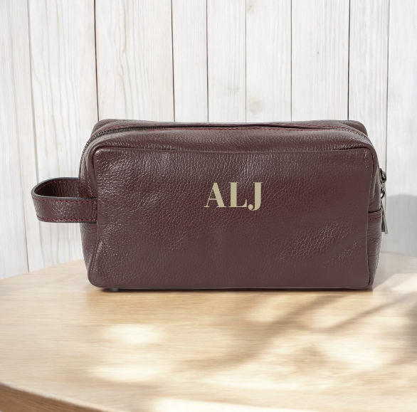 Neceser de piel personalizado con iniciales bordadas, diseño elegante y práctico para regalo.

